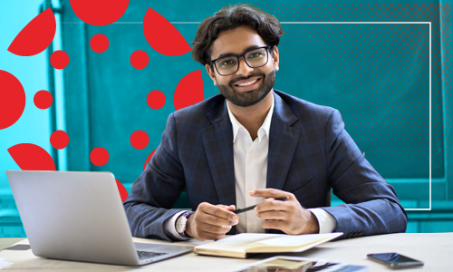 Professor at desk with canvas logo in the background